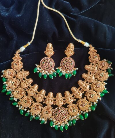 Premium Exclusive Gold Bridal Necklace Adorned with Lakshmi Goddess, Pakshi Pendants highlighted with Pearls and Green Beads and Real Kemp Stones