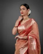 "Close-up of an orange crushed tissue silk saree, highlighting its unique crinkle effect."By Mirra Clothing