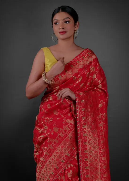 Front view of a model showcasing a Peachy Red Banarasi Silk Saree Highlighted with Embroidery, Suitable for traditional performances or fairs By Mirra Clothing