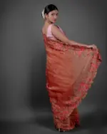 Back view of a model showcasing Red Crushed Tissue Silk Saree With Cutwork Embroidery, Perfect for celebrating achievements like promotions or graduations By Mirra Clothing