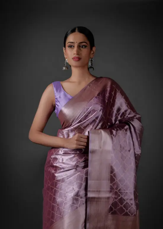 "Elegant lavender tissue silk saree featuring intricate zari weaves and delicate patterns."By Mirra Clothing