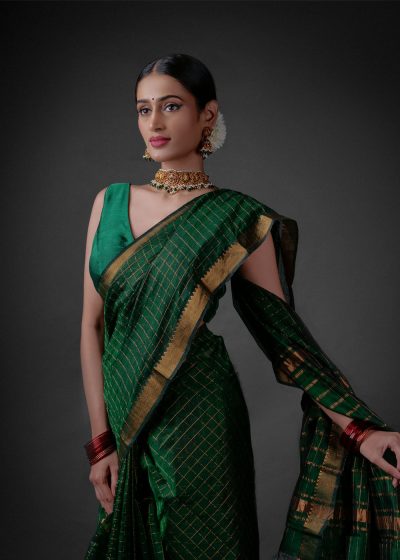 A model wearing a Bottle Green Mangalagiri silk saree by Mirra Clothing