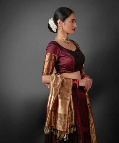 Side view of a model showcasing Coffee Brown Silk Half Saree Set with Tissue Silk Dupatta, Designed for festive wedding occasions By Mirra Clothing
