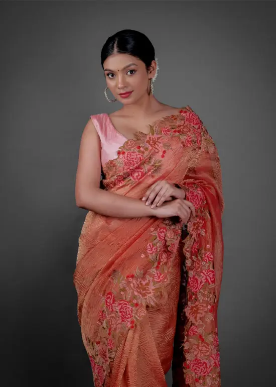 Front view of a model showcasing a Red Crushed Tissue Silk Saree With Cutwork Embroidery, Perfect for capturing special moments or portraits. By Mirra Clothing
