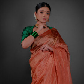 Close up view of a model showcasing Orange Tissue Silk Saree , Suitable for festive times By Mirra Clothing