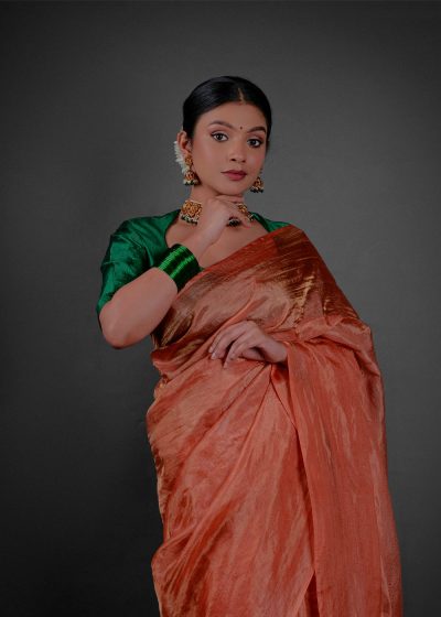 Close up view of a model showcasing Orange Tissue Silk Saree , Suitable for festive times By Mirra Clothing