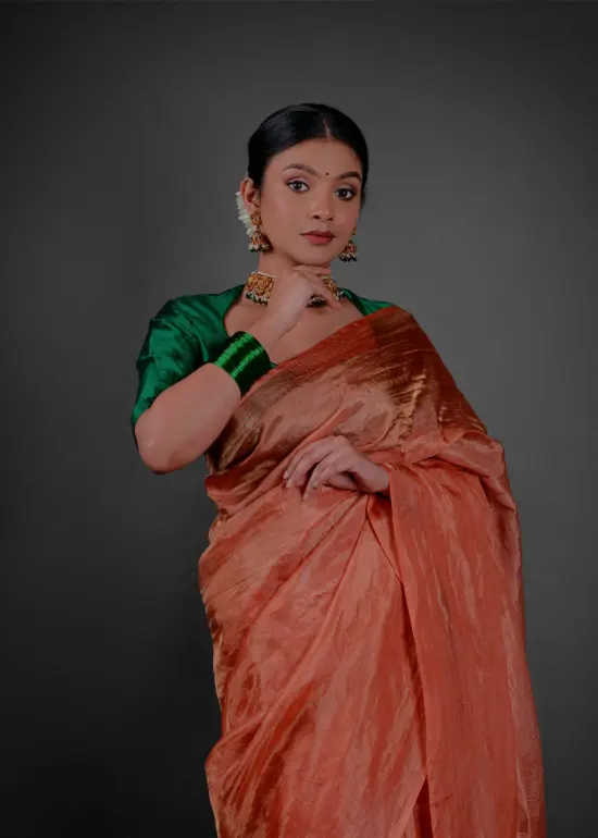 Close up view of a model showcasing Orange Tissue Silk Saree , Suitable for festive times By Mirra Clothing