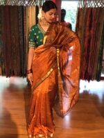 Full view of a model showcasing Honey Orange Mangalagiri Silk Saree Handwoven in Gold Zari Chequered Pattern, Suitable For Festivals & Religious Celebrations By Mirra Clothing