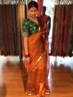 Close up view of a model showcasing Honey Orange Mangalagiri Silk Saree Handwoven in Gold Zari Chequered Pattern, Suitable For Formal Events & Anniversaries By Mirra Clothing