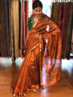 Side view of a model showcasing Honey Orange Mangalagiri Silk Saree Handwoven in Gold Zari Chequered Pattern, Suitable For Cultural Gatherings & Temple Visits By Mirra Clothing