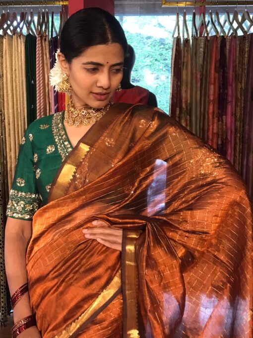 "Front view of a model showcasing a Honey Orange Mangalagiri Silk Saree Handwoven in Gold Zari Chequered Pattern, Suitable For Engagement or Sangeet Functions By Mirra Clothing
