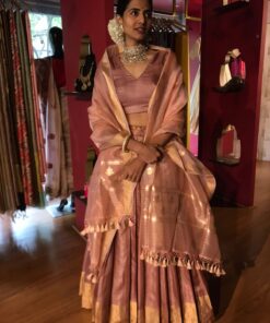 Model wearing a dusty pink tussar silk dupatta draped over the shoulderbshowcasing its soft texture and natural sheen the duputta complements her traditional attire