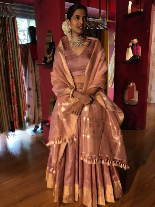 Model wearing a dusty pink tussar silk dupatta draped over the shoulderbshowcasing its soft texture and natural sheen the duputta complements her traditional attire