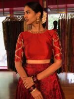 Close up image of model wearing a maroon embroidered lehenga set suitable for wedding by mirra clothing