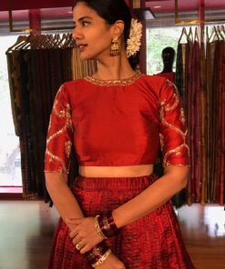 Close up image of model wearing a maroon embroidered lehenga set suitable for wedding by mirra clothing