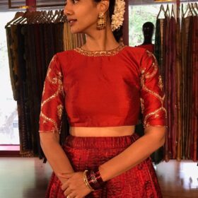 Close up image of model wearing a maroon embroidered lehenga set suitable for wedding by mirra clothing