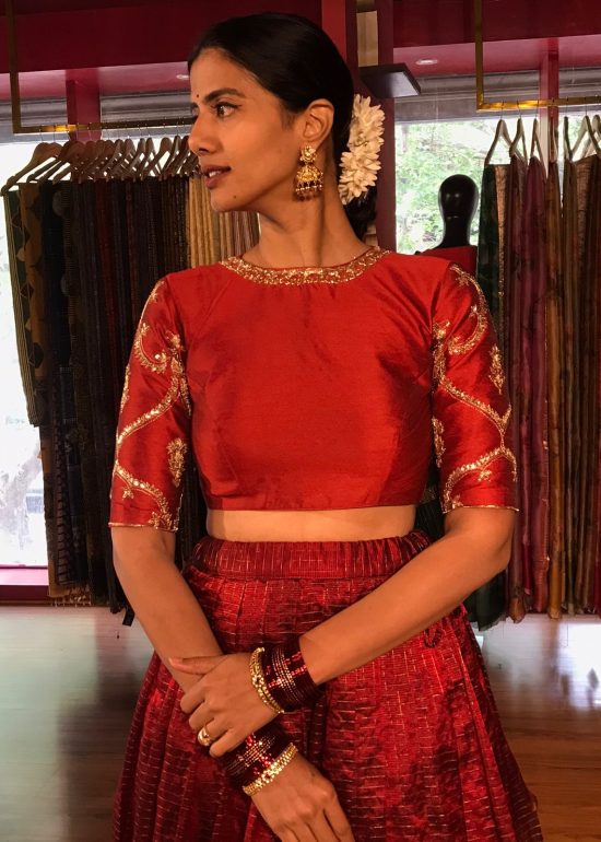 Close up image of model wearing a maroon embroidered lehenga set suitable for wedding by mirra clothing